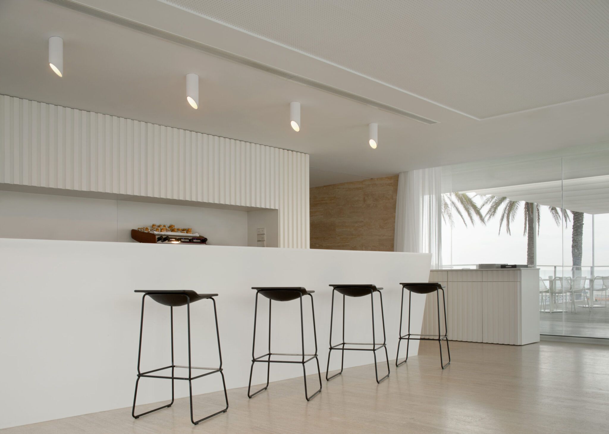 plafonnier 45° de Vibia au dessus dun bar blanc